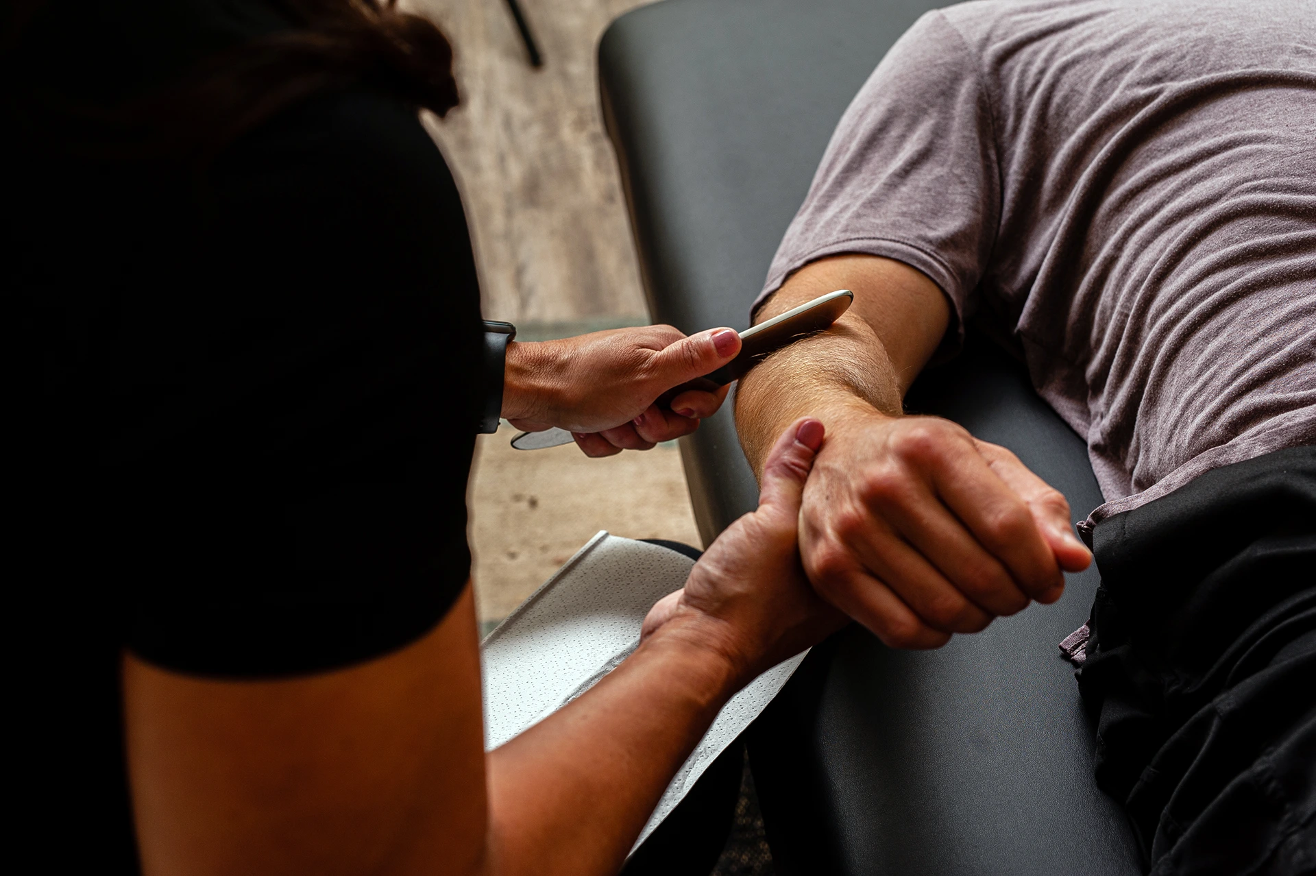 Graston technique (muscle scraping) being performed on a client